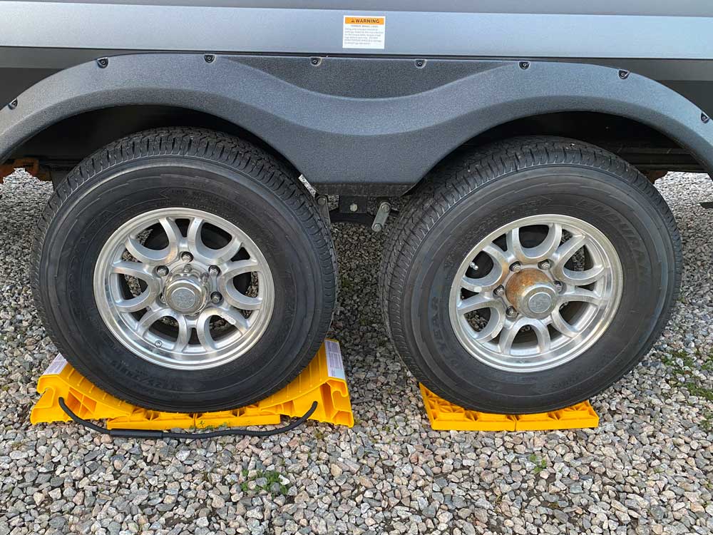 Camco chocks and blocks shown with travel trailer tires