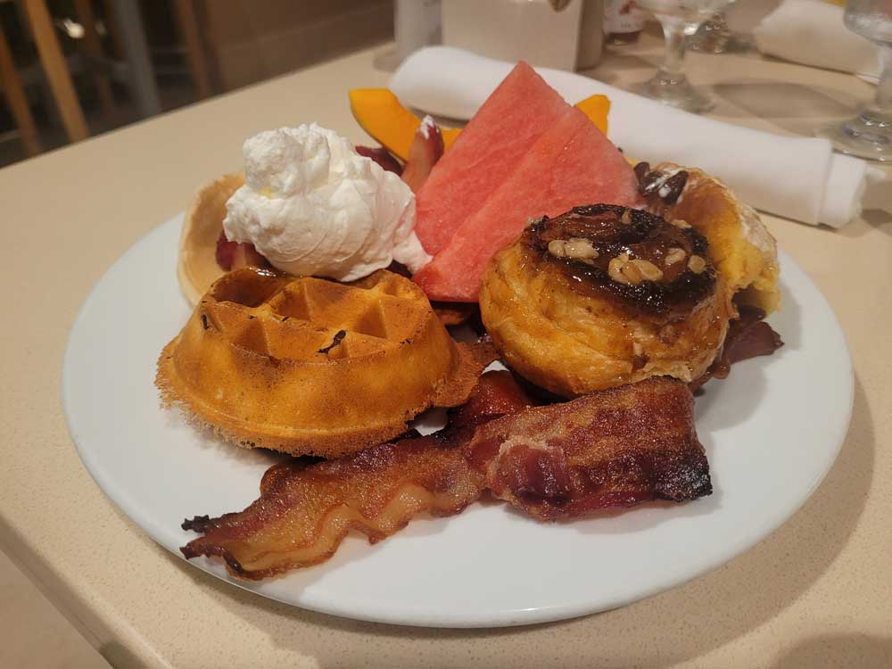 Hearty breakfast with waffles, cinnamon bun, and bacon at Waikiki Beach Marriott