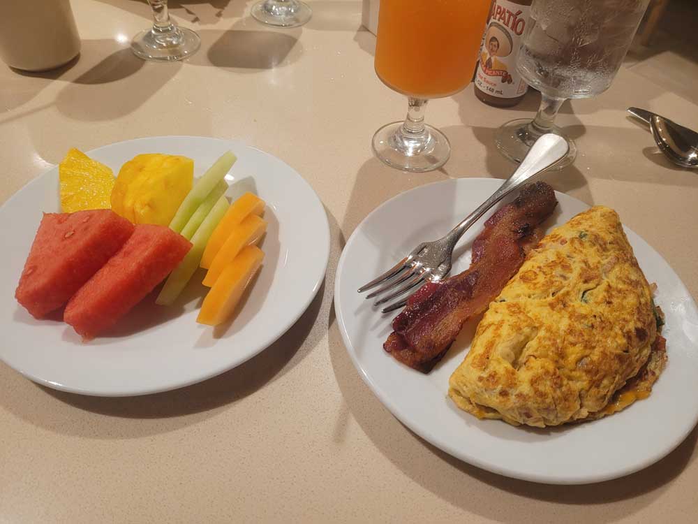 Hearty breakfast with omelet, bacon, and fruit plate at Waikiki Beach Marriott