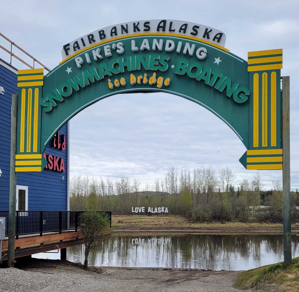 Pike's Landing sign with view of river and Love Alaska sign