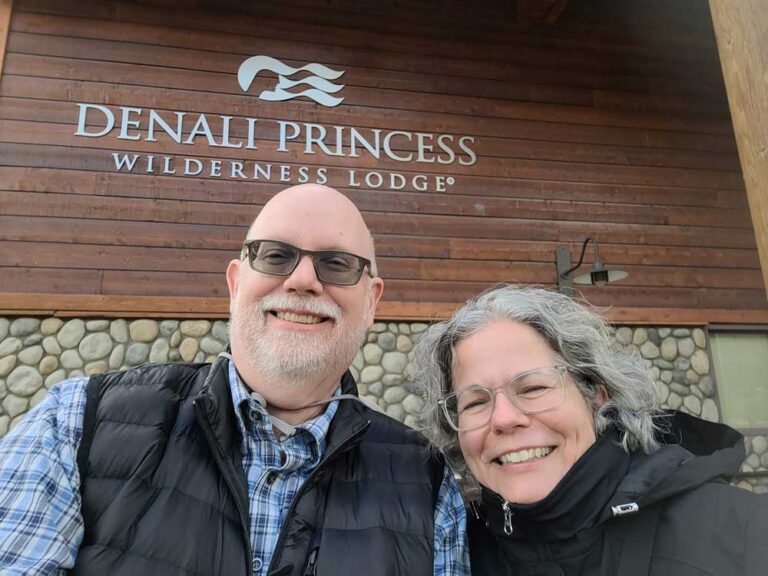 Erling and Judy standing by the sign for the Denali Princess Wilderness Lodge