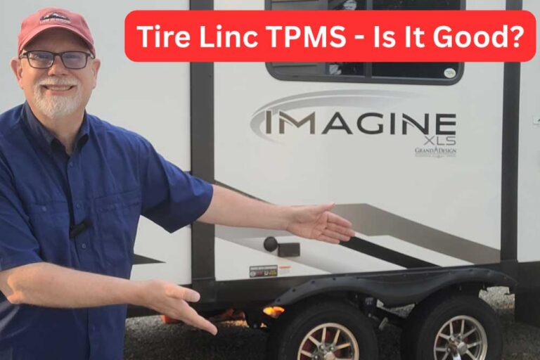 Erling in front of Imagine camper pointing at tires