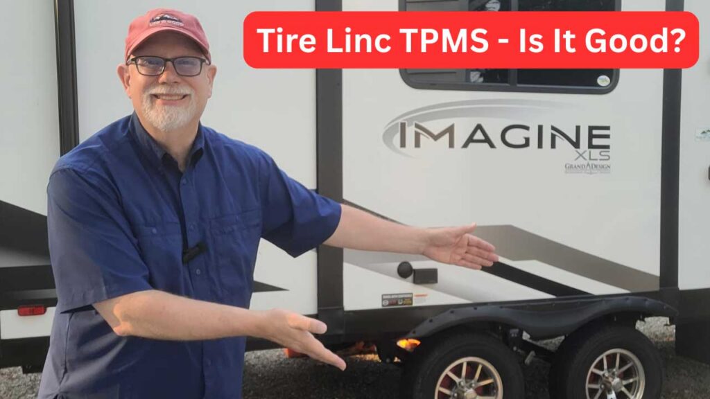 Erling in front of Imagine camper pointing at tires