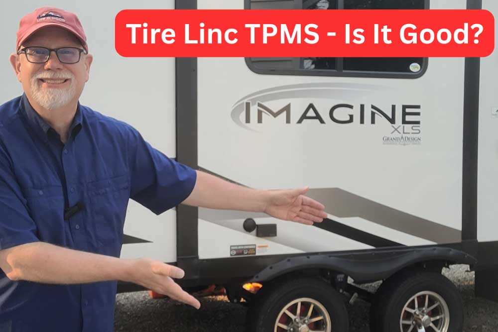 Erling in front of Imagine camper pointing at tires