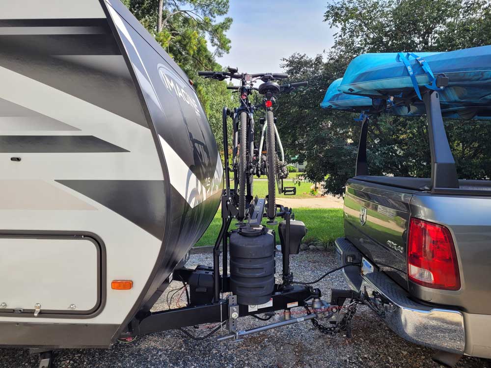 Side view of camper with Arvika bike rack and truck with kayaks